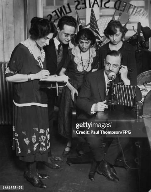 United State Line operating manager Thomas H Rossbottom receives a message from United State Line ship 'America', with staff members in his office on...