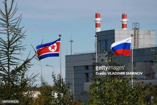 In this pool photograph distributed by Sputnik agency, Russian and North Korean flags flutter at the Vostochny cosmodrome, Amur region, on September...