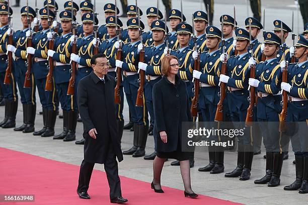 Chinese Premier Li Keqiang accompanies Australian Prime Minister Julia Gillard to view an honour guard during a welcoming ceremony outside the Great...