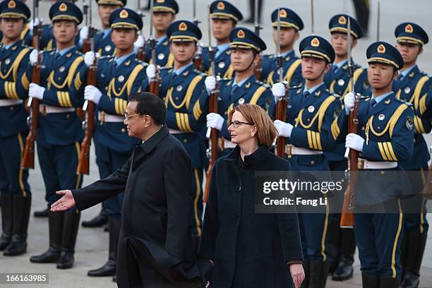 Chinese Premier Li Keqiang accompanies Australian Prime Minister Julia Gillard to view an honour guard during a welcoming ceremony outside the Great...