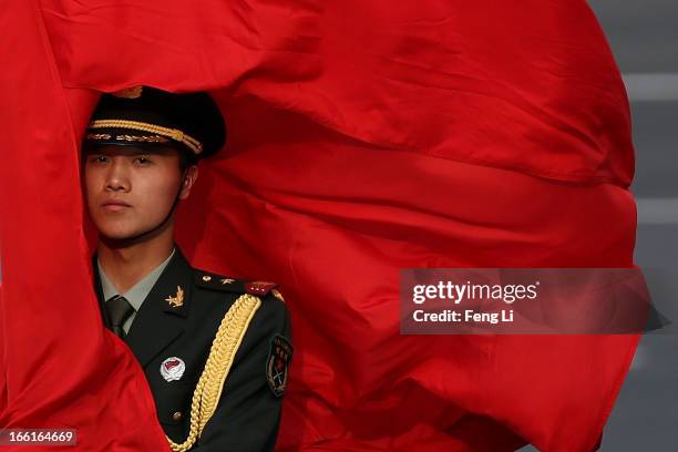 The wind blows a red flag onto the face of an honour guard before a welcome ceremony for Australia's Prime Minister Julia Gillard outside the Great...