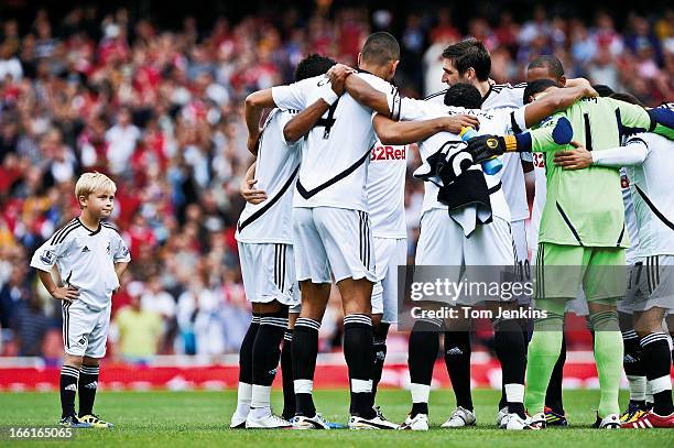 The disgruntled Swansea City mascot looks on as the players have a huddle without him just before kick-off in the Premier League match versus Arsenal...