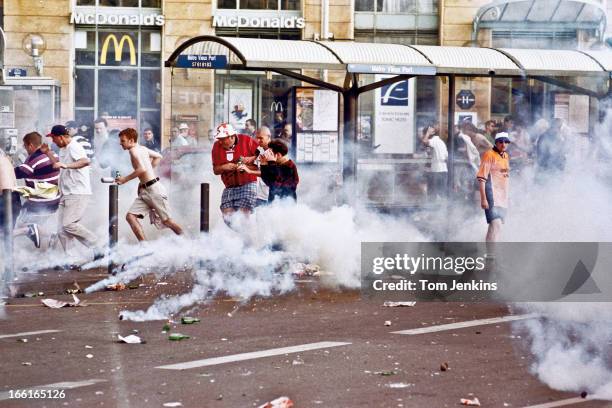 England football fans flee tear-gas canisters during a riot the day before England started their FIFA World Cup campaign in Marseille, France on June...