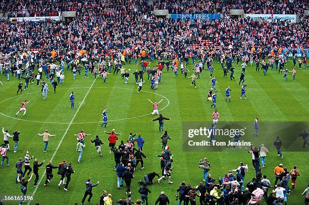 Celebrating fans invade the pitch as Stoke City gain promotion to the Premier League after a 0-0 draw with Leicester City in their Championship match...