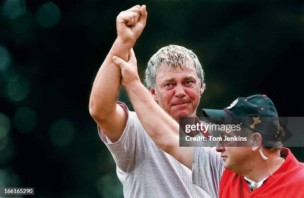 Darren Clarke of the European team has his arm raised in triumph by his captain Ian Woosnam after Clarke won his singles match versus Zach Johnson of...