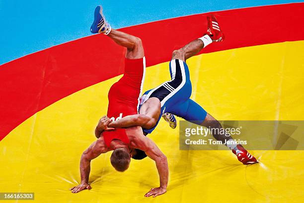 Farid Mansurov of Azerbaijan throws Ryszard Wolny of Poland during a bout in the 66kg division of Olympic Greco-Roman wrestling at the Ano Liosia...