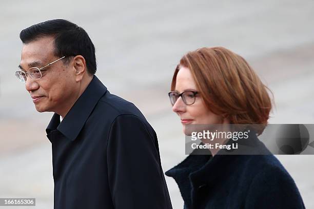 Chinese Premier Li Keqiang accompanies Australian Prime Minister Julia Gillard to view an honour guard during a welcoming ceremony outside the Great...