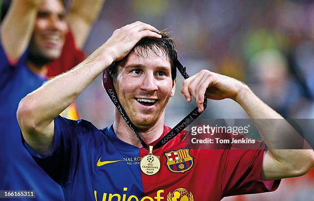 Lionel Messi of Barcelona celebrates victory with his winner's medal round his head after his side beat Manchester United in the 2009 Champions...