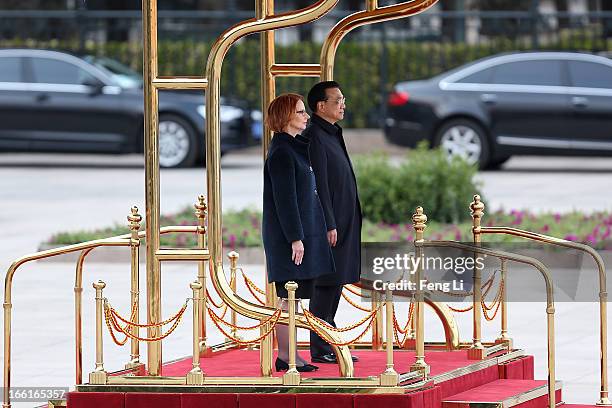 Chinese Premier Wen Jiabao and Australian Prime Minister Julia Gillard listen to their national anthems during a welcoming ceremony outside the Great...