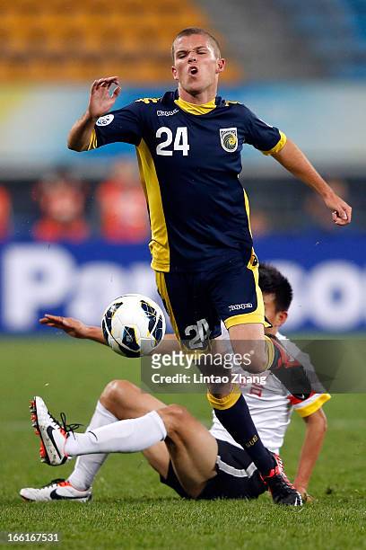 Hayden Morton of the Mariners challenges Rao Weihui of Guizhou Renhe during the AFC Champions League match between Guizhou Renhe and Central Coast...