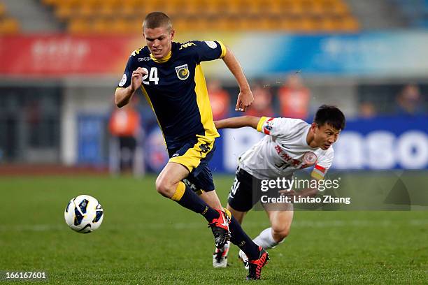 Hayden Morton of the Mariners challenges Rao Weihui of Guizhou Renhe during the AFC Champions League match between Guizhou Renhe and Central Coast...