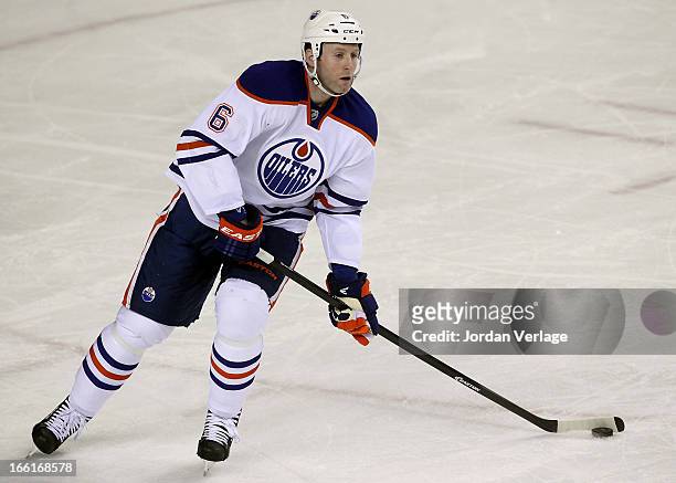 Ryan Whitney of the Edmonton Oilers handles the puck during a game against the Calgary Flames at Scotiabank Saddledome on April 3, 2013 in Calgary,...