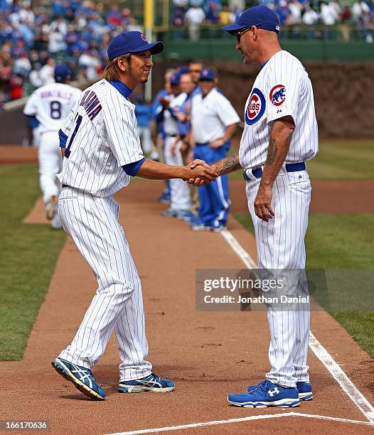 Kyuji Fujikawa of the Chicago Cubs shakes hands with manager Dale Sveum during player introductions before the Opening Day game against the Milwaukee...