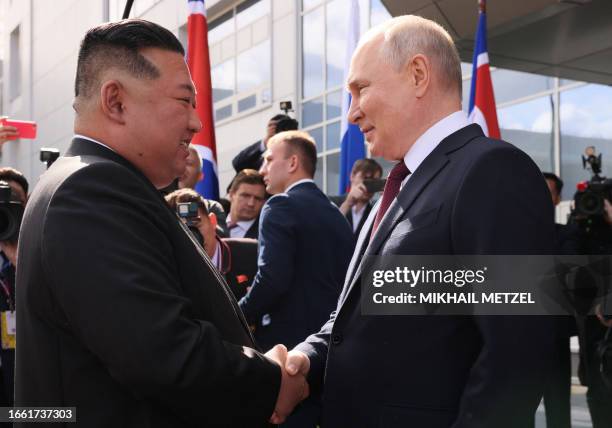 In this pool photo distributed by Sputnik agency, Russia's President Vladimir Putin shakes hands with North Korea's leader Kim Jong Un during their...