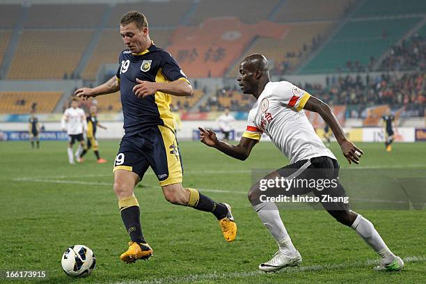 Mitchell Duke of the Mariners challenges Jonas Salley of Guizhou Renhe during the AFC Champions League match between Guizhou Renhe and Central Coast...