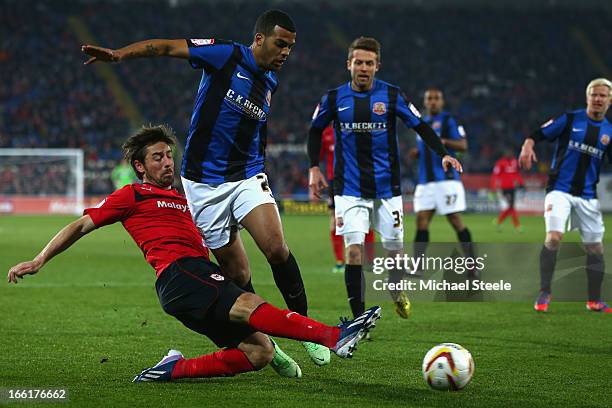 Tommy Smith of Cardiff City hooks the ball past the challenge of Jacob Mellis of Barnsley during the npower Championship match between Cardiff City...
