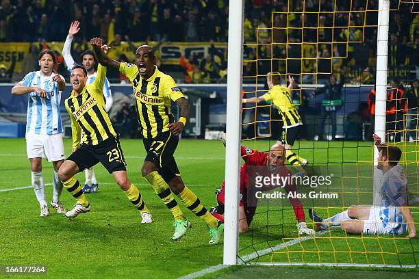 Felipe Santana of Borussia Dortmund celebrates scoring their third and winning goal with team mate Julian Schieber as goalkeeper Willy Caballero and...