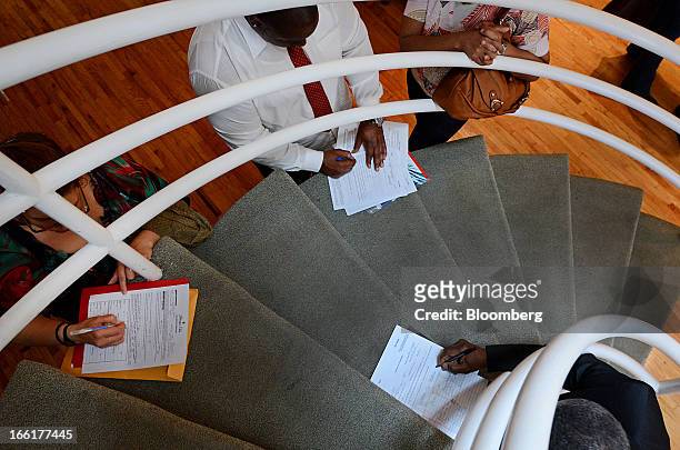 Job seekers fill out applications during the NYC Restaurant Job Expo at the Gabarron Foundation in New York, U.S., on Tuesday, April 9, 2013. The...