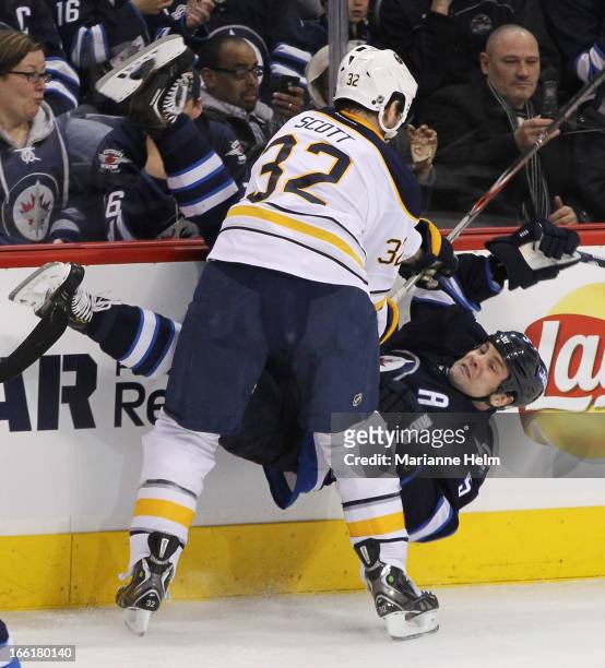 John Scott of the Buffalo Sabres takes down Mark Stuart of the Winnipeg Jets during first-period action in a game against the Buffalo Sabres on April...