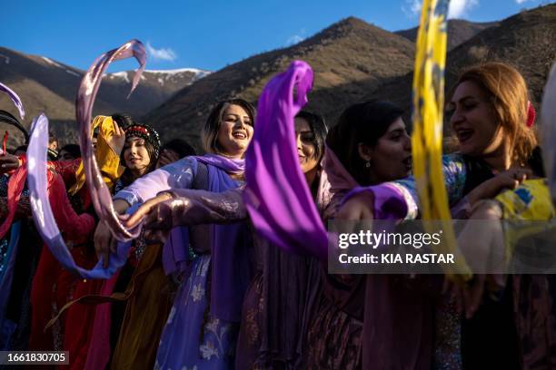 Kurdistan, Iran. Iranian Kurdish women, dressed in traditional colorful Kurdish costumes, participate in celebratory dances during Nowruz, which...
