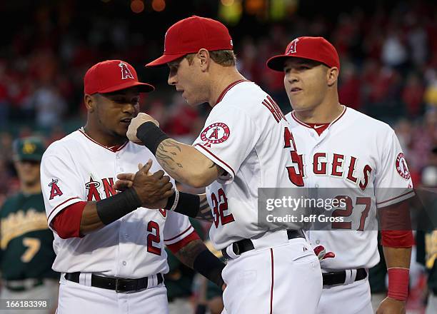 Erick Aybar, Josh Hamilton and Mike Trout greet one another prior to the start of the home opener against the Oakland Athletics at Angel Stadium of...