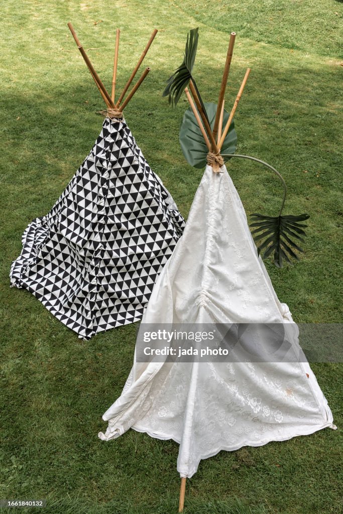 Two wigwam tents are outside on the lawn
