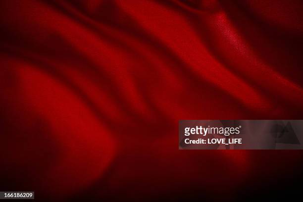 a red satin cloth background with wrinkles - rood stof stockfoto's en -beelden