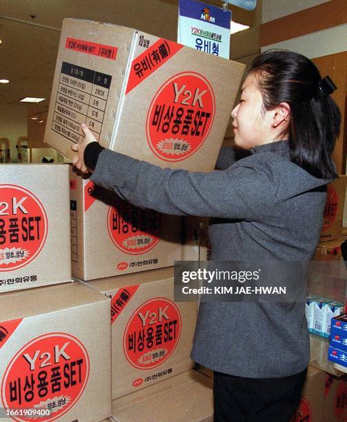 An employee at Hawha Mart, a large-scale supermarket in Seoul, 30 November 1999, displays a Y2K emergency kit prepared for possible disasters that...