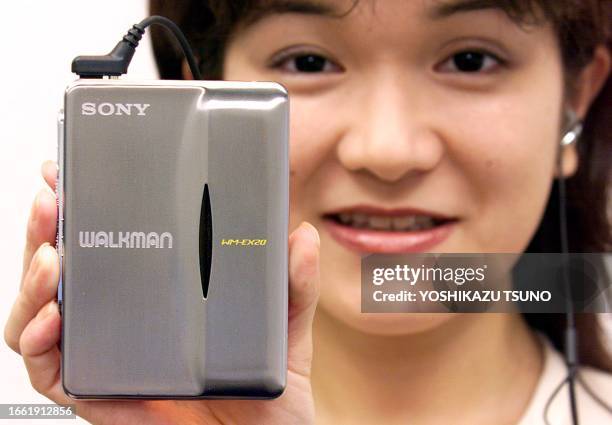 Fumie Kagaya, an employee of Japan's electronics giant Sony displays the 20th anniversary model of a Walkman cassette player WM-EX20 which model has...