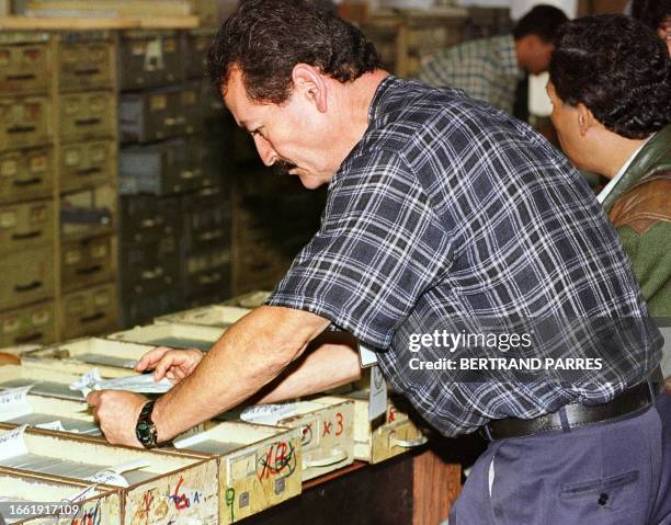 An employee of the voter registation office checks official papers 23 July in Caracas. Hundreds of people are attempting to register to vote in the...