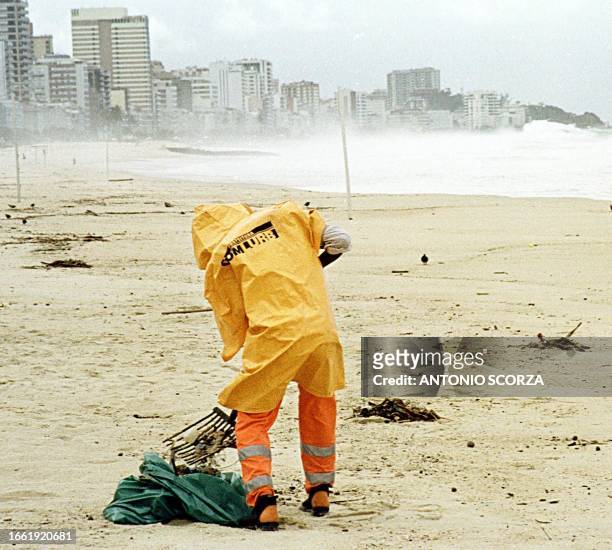 An employee of Rio de Janeiro cleans up Ipanema Beach 31 May 1999 in preparations for the reopening of the beach after a sewage leak closed the...