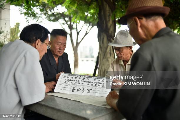 People read the "Rodong Sinmun" newspaper in Pyongyang on September 13 featuring a story about the arrival of North Korea's leader Kim Jong Un at the...