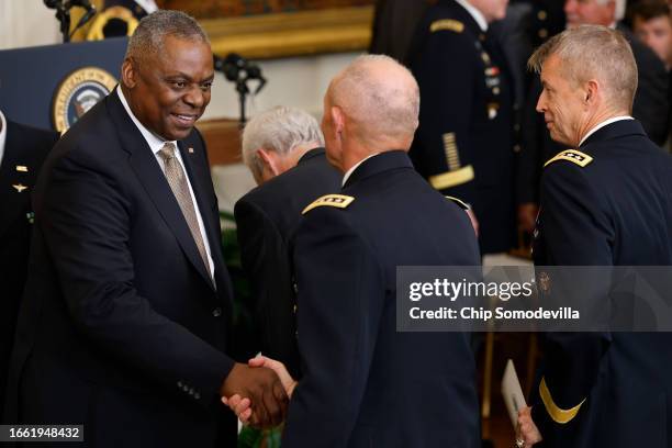 Secretary of Defense Lloyd Austin greets Army generals during the Medal of Honor ceremony for retired U.S. Army Captain Larry Taylor in the East Room...