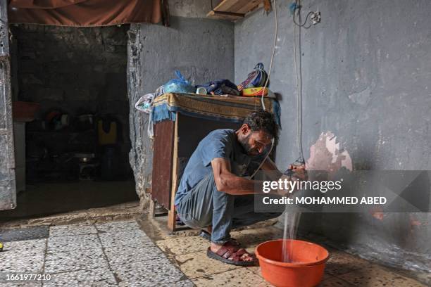 Man removes water from his house in Gaza City following heavy rainfall, on September 13, 2023.