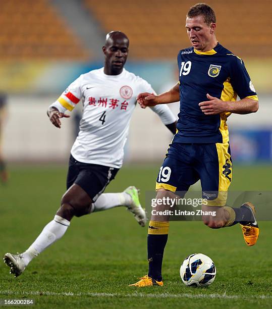 Mitchell Duke of the Mariners challenges Jonas Salley of Guizhou Renhe during the AFC Champions League match between Guizhou Renhe and Central Coast...