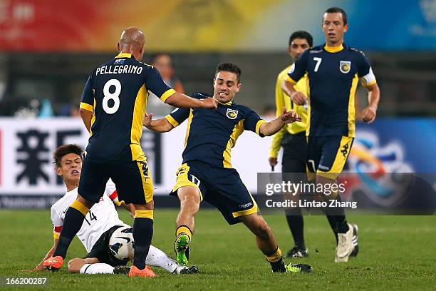 Yang Yihu of Guizhou Renhe challenges Adriano Pellegrino and Anthony Caceres of the Mariners during the AFC Champions League match between Guizhou...