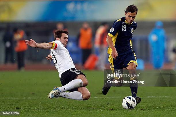 Trent Sainsbury of the Mariners challenges Zvjezdan Misimovic of Guizhou Renhe during the AFC Champions League match between Guizhou Renhe and...