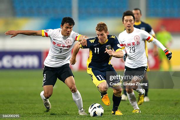 Oliver Bozanic of the Mariners challenges Zhang Chenglin and Yang Hao of Guizhou Renhe during the AFC Champions League match between Guizhou Renhe...