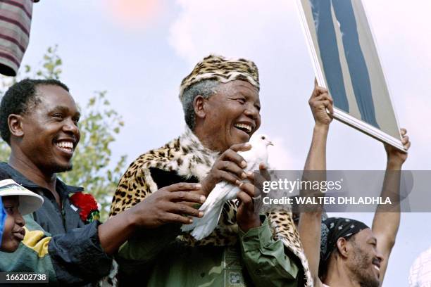 African National Congress President Nelson Mandela, wearing leopard skin traditional clothes, releases a white dove for peace at a rally to...