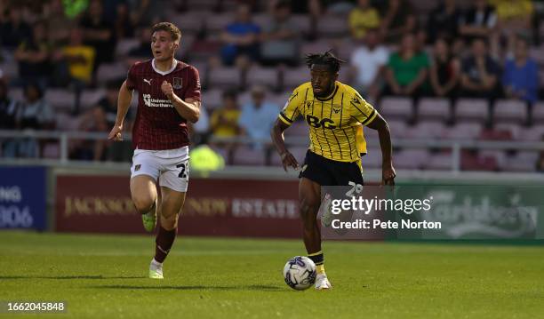 Kyle Edwards of Oxford United moves forward with the ball away from Harvey Lintott of Northampton Town during the EFL Trophy match between...
