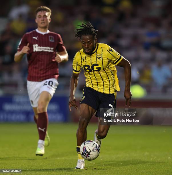 Kyle Edwards of Oxford United moves forward with the ball away from Harvey Lintott of Northampton Town during the EFL Trophy match between...