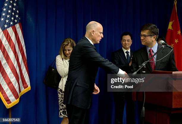 Ambassador to China Gary Locke shakes hands with California Governor Jerry Brown as Chinese Vice Minister of Commerce Wang Chao looks on during a...