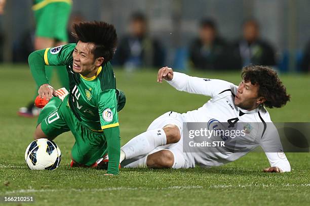 Uzbekistan Bunyodkor's Hayrulla Karimov tussles for the ball against Beijing Guoan's Zhang Xizhe during the AFC Champions League group G match at the...