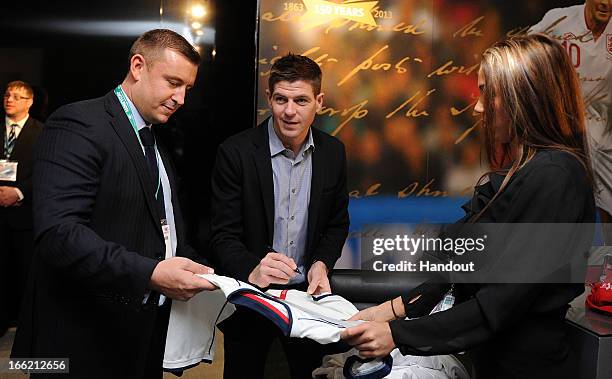 In this handout image provided by The FA, Steven Gerrard autographs a football shirt in the FA150 lounge during the Soccerex European Forum...