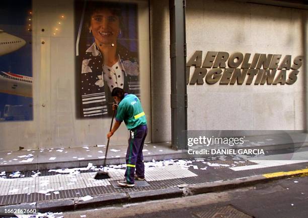 Municipal employee sweeps pamphlets thrown during a demonstration of workers of Aerolineas Argentinas, which took place in front of the company's...