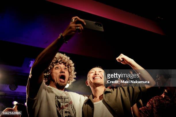 two men taking selfies with their cell phones at a live music club. - short phrase stock pictures, royalty-free photos & images