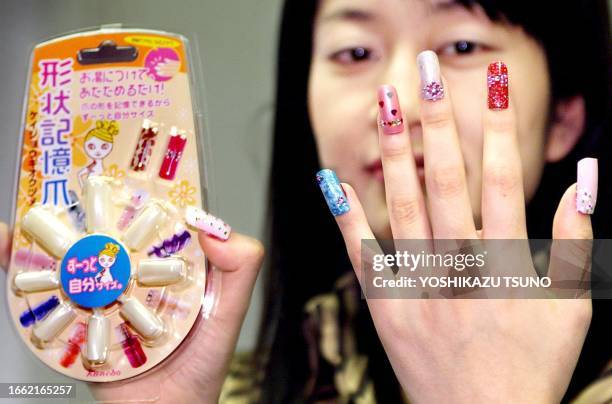 Japanese cosmetics maker Kanebo employee Seiko Kuwahata displays colorful false nails "Nail Vavi" made of the world's first shape-memory resin, which...