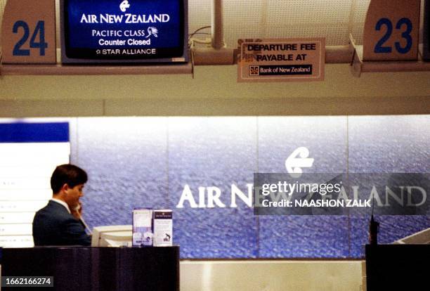 An Air New Zealand employee works at an empty counter at Auckland International Airport, 18 September 2001. The airline's value has plunged in the...