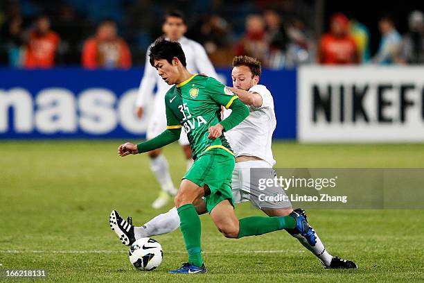 Oleksandr Pyschur of Bunyodkor challenges Li Tixiang of Beijing Guoan during the AFC Champions League Group match between Bunyodkor and Beijing Guoan...