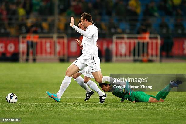 Oleksandr Pyschur and Kamoliddin Murzoev of Bunyodkor challenges Li Tixiang of Beijing Guoan during the AFC Champions League Group match between...